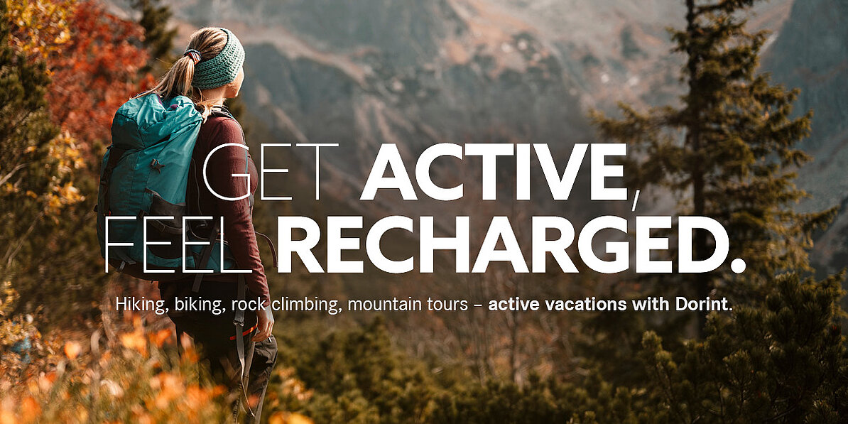 Hiker with a backpack on a mountain trail in an alpine landscape overlooking the mountains. Active holiday with hiking and nature experiences at Dorint.