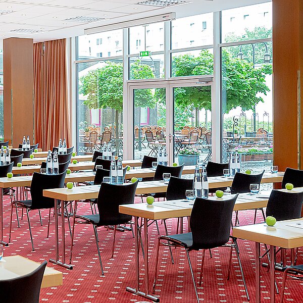 Seminarraum mit Fensterfront zum Biergarten und rotem Teppichboden
