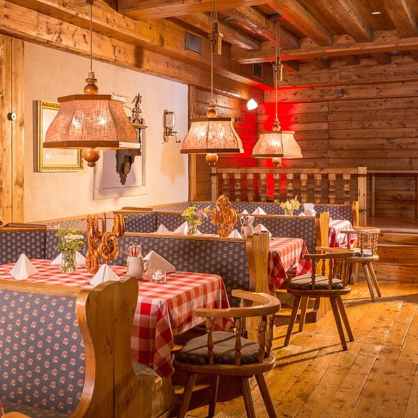 Bayerische Stuberl mit Holzböden, Tischen und Stühlen und traditionell bayerischen Dekoelementen
