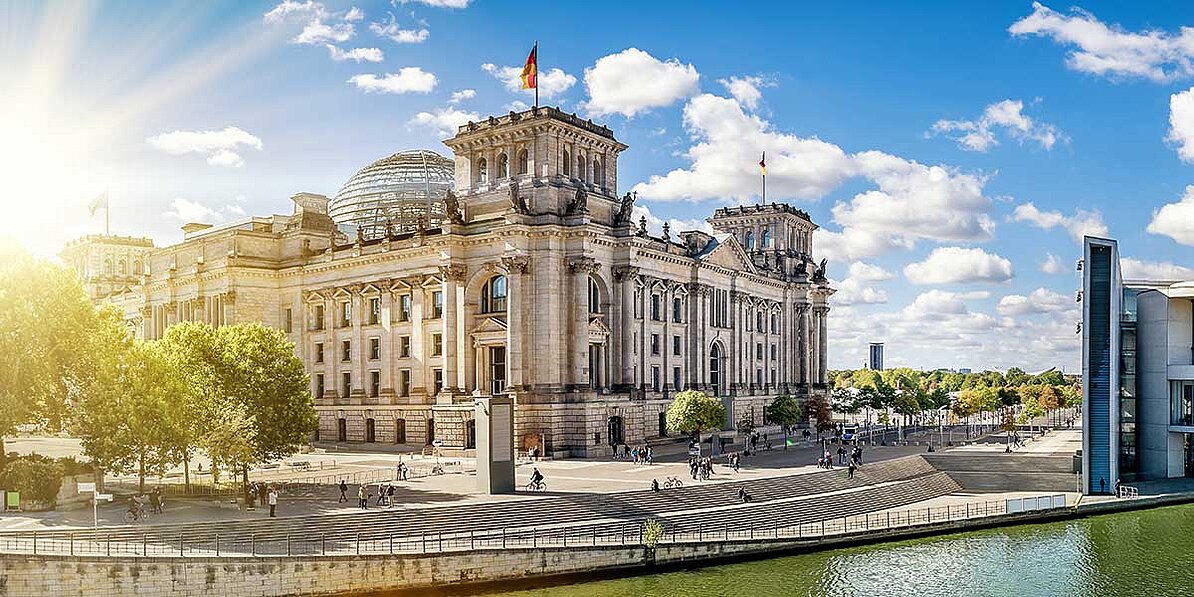 Das Bild zeigt das Reichstagsgebäude in Berlin an einem sonnigen Tag.