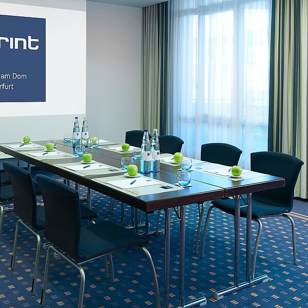 Moderner Meetingraum mit blauem Teppichboden und Blockbestuhlung