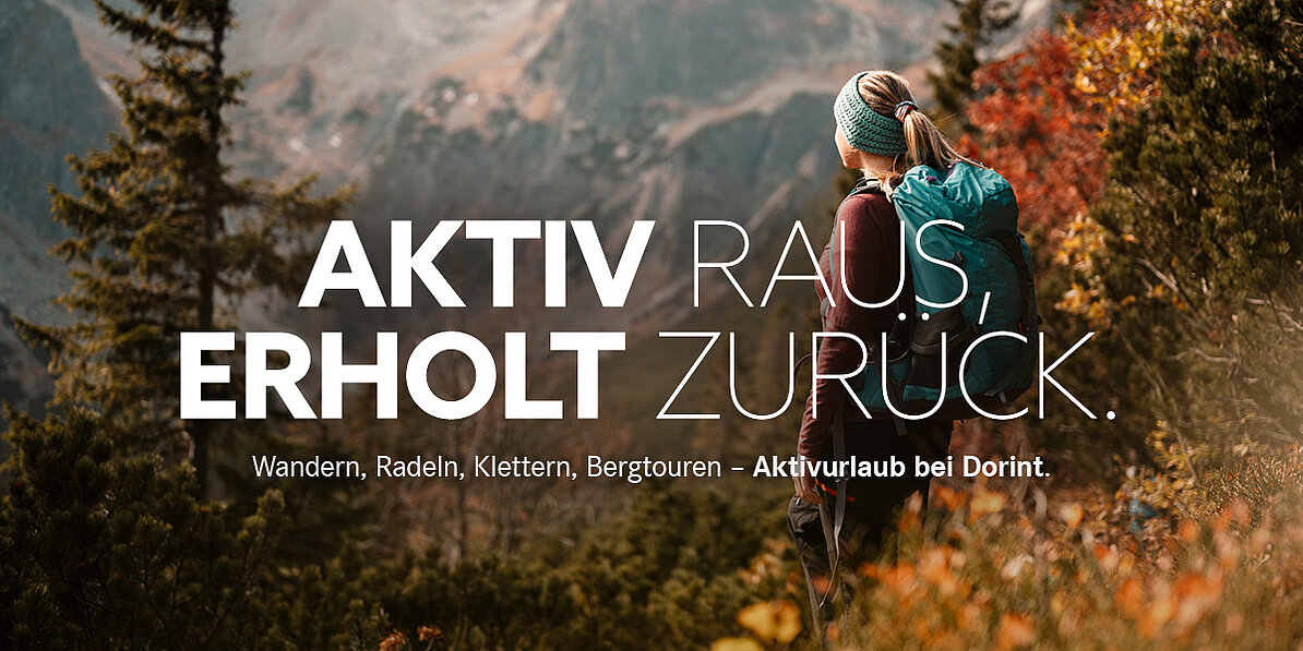 Wandernde Person mit Rucksack auf einem Bergpfad in alpiner Landschaft mit Blick auf die Berge. Aktivurlaub mit Wandern und Naturerlebnis bei Dorint.