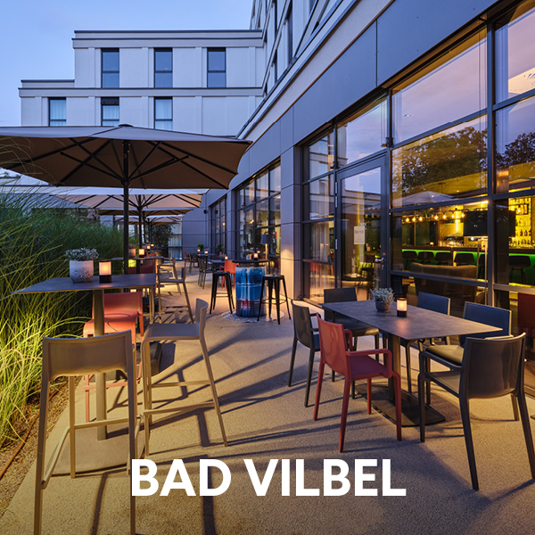 Dorint Parkhotel Frankfurt/Bad Vilbel mit moderner Außenterrasse, Sitzplätzen und Sonnenschirmen bei Abendlicht – Sommerurlaub und Städtetrip nahe Frankfurt