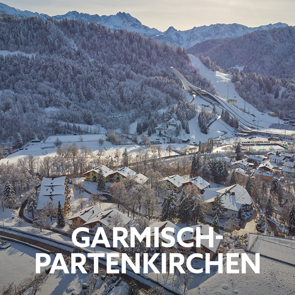 Snow-covered mountain landscape overlooking Garmisch-Partenkirchen and the surrounding Alps. An ideal destination for active holidays with winter hiking, skiing and outdoor adventures.