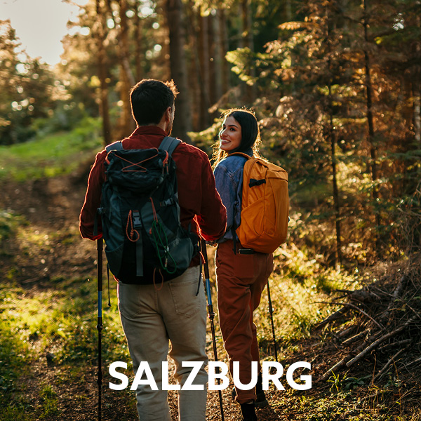 Hikers with backpacks on a forest trail near Salzburg. Active holidays with hiking, outdoor adventures and nature experiences in a diverse landscape.