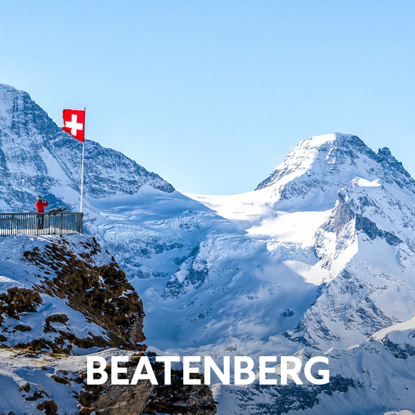 Snow-covered alpine landscape near Beatenberg with a viewpoint and Swiss flag. Active holidays in Switzerland with winter hiking, outdoor adventures and breathtaking mountain views.
