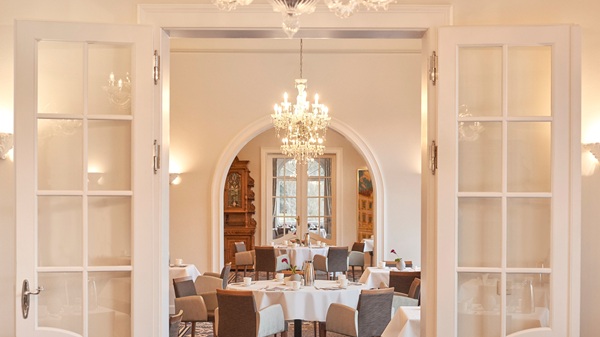 Restaurant im Dorint Resort & Spa Bad Brückenau mit gedeckten Tischen und eleganten Kronleuchtern