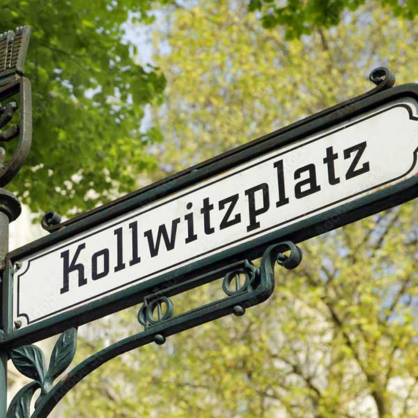 Das Bild zeigt ein Straßenschild mit der Aufschrift "Kollwitzplatz".