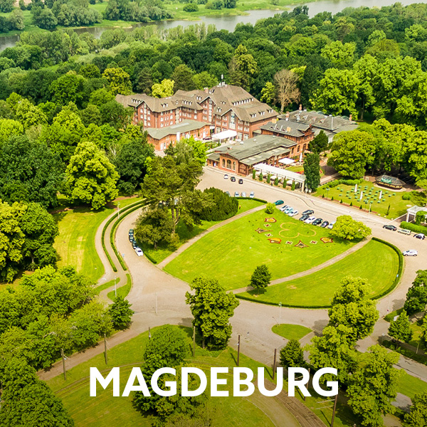 Blick von oben auf den Herrenkrug-Park in Magdeburg mit grünen Wiesen, Bäumen und dem Dorint Herrenkrug Parkhotel Magdeburg 